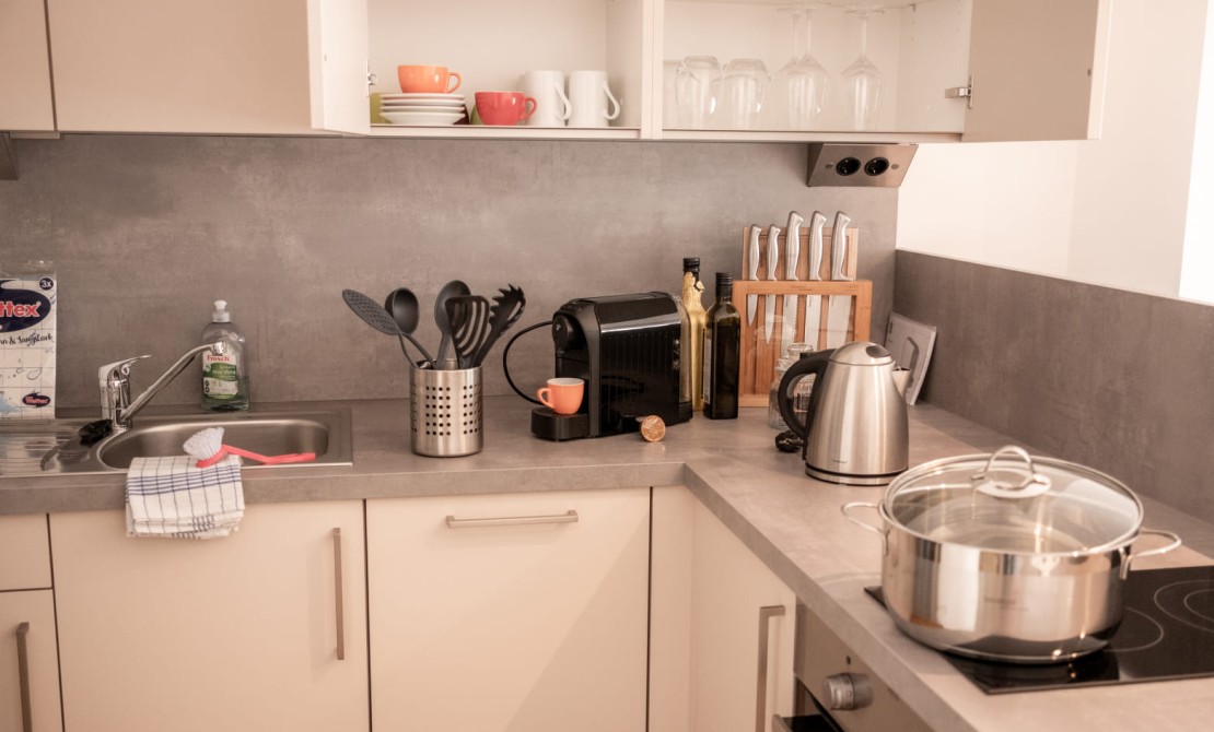 Apartment kitchen with stove, coffee machine, and complete equipment