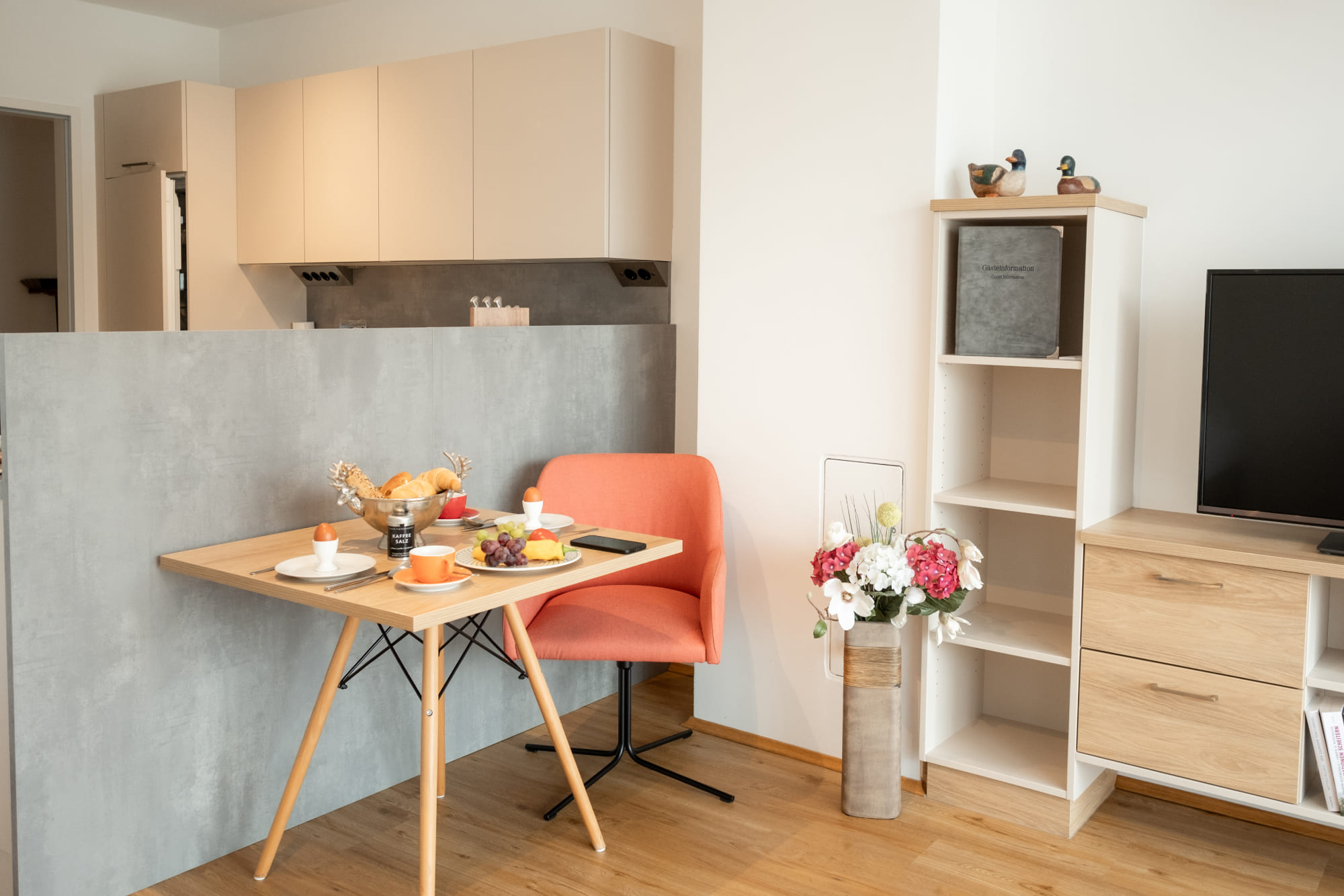 Bright living area of an apartment in the Waldviertel with a kitchenette and a set dining table